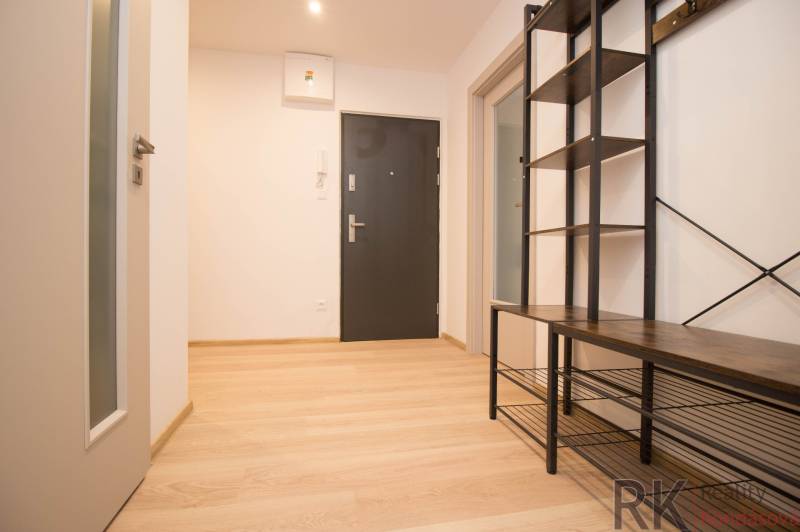 The entrance hall of a 3-room apartment with a wooden decor floor and metal furniture.