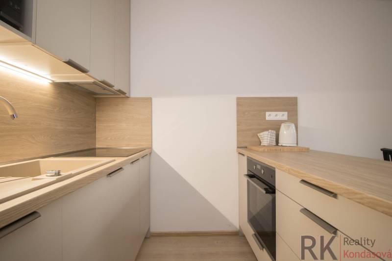 A kitchen unit with a wooden decor floor in a 3-room apartment.