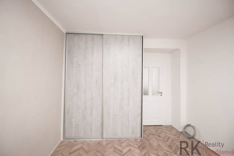 A wardrobe with sliding doors in a two-room apartment, a floor with a wooden decor.