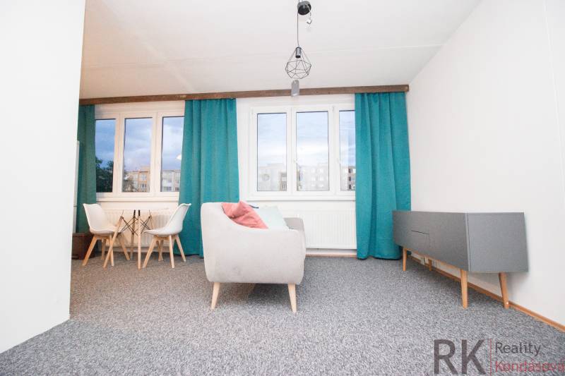 Living room in a 4-room apartment with blue curtains and gray furniture.