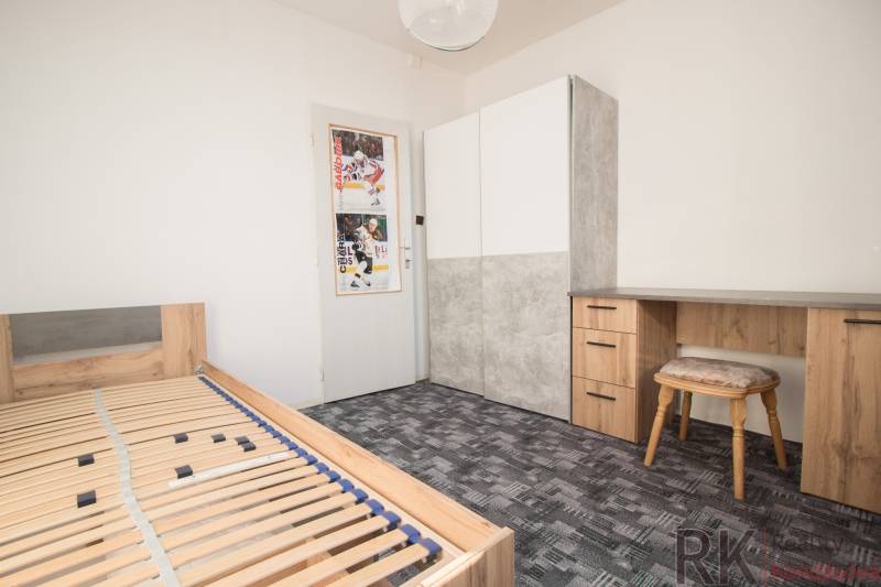 Bedroom in a 4-room apartment with a bed, a desk, and a wardrobe.
