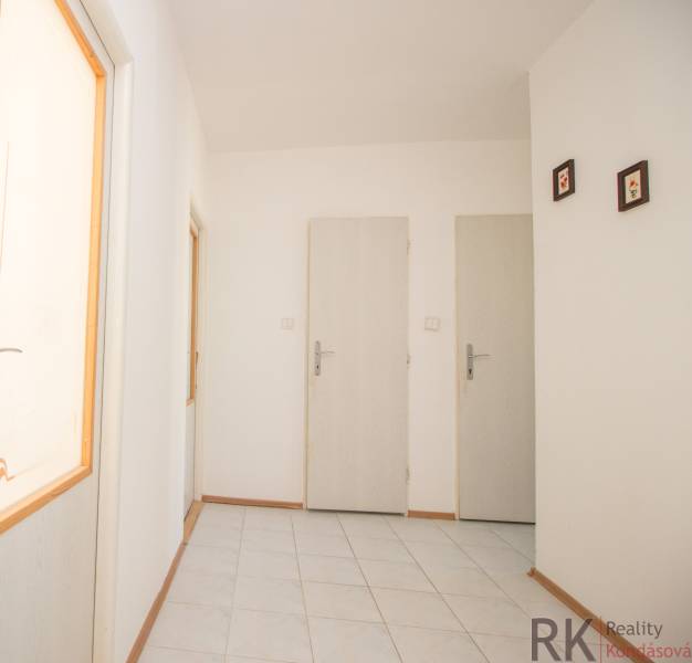 A hallway with light walls and white doors in a 4-room apartment.