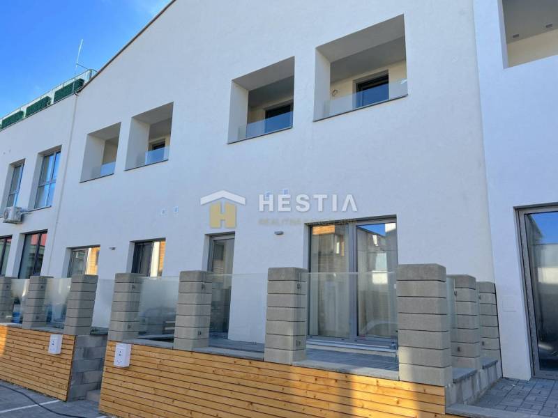 A new building with multiple balconies and a 2-room apartment, a concrete fence, and a terrace.