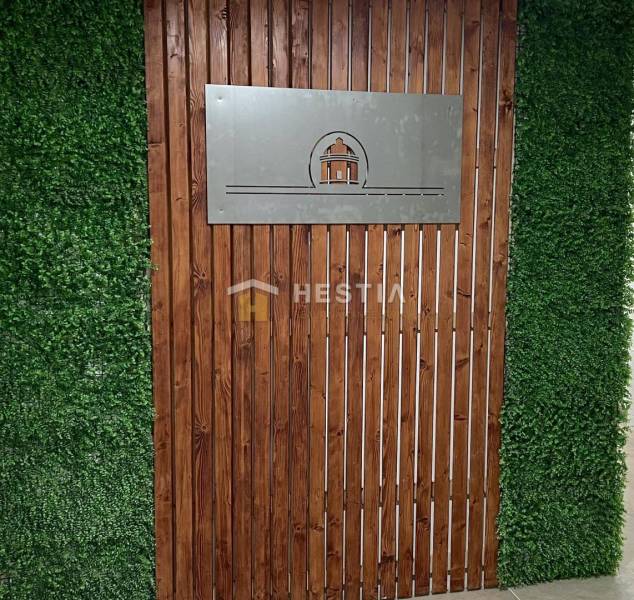 A wall made of wood and greenery with a logo. Suitable for a 2-room apartment.