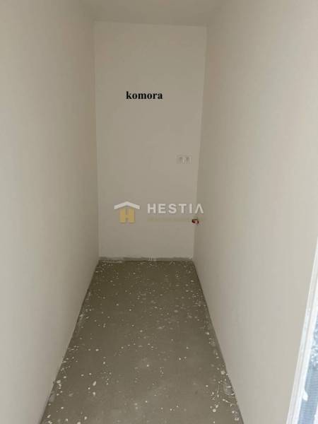 A small pantry room in a 2-room apartment with white walls and a concrete floor.