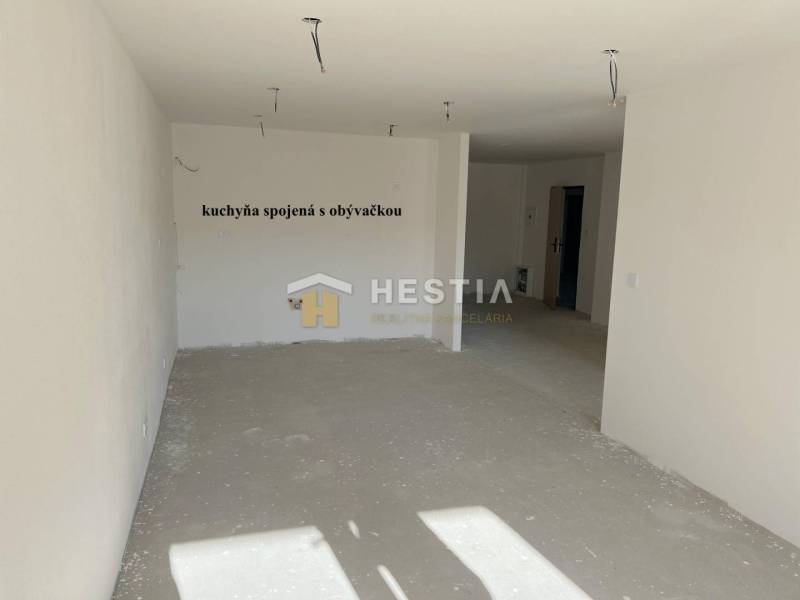 An empty living room connected to the kitchen, suitable for furnishing a 2-room apartment.