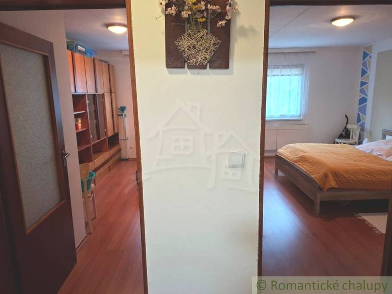 Interior of a family house with a wooden decor floor, bedroom, and storage space.