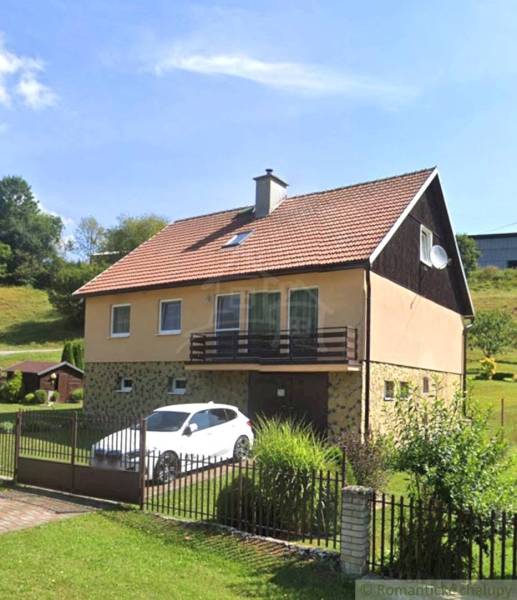 A family house in Liptovské Revúce with a garage and a garden on a sloped plot.
