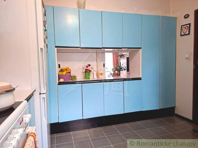 A kitchen in a family house with blue cabinets and white appliances.