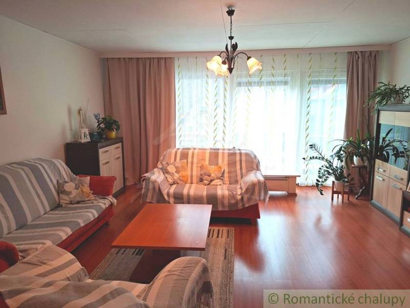 Living room in a family house with a wooden decor floor, light, and sofas.