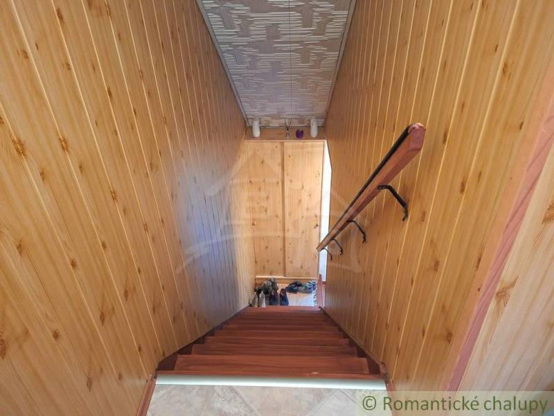 Interior of a family house with wooden wall paneling and a staircase with a wooden decor.
