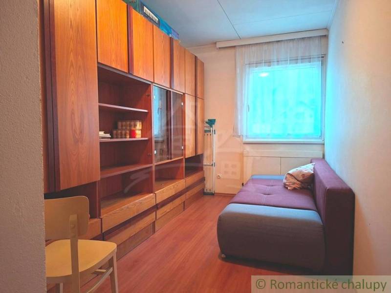 A room with a sofa, cabinets, and a wooden decor floor in a family house.
