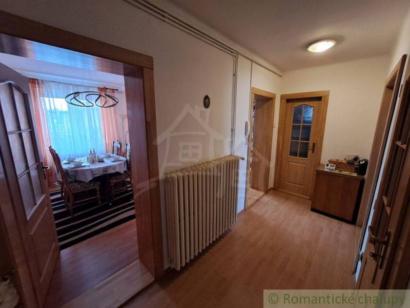 A hallway with a wooden decor floor in a family house, cozy furniture arrangement.