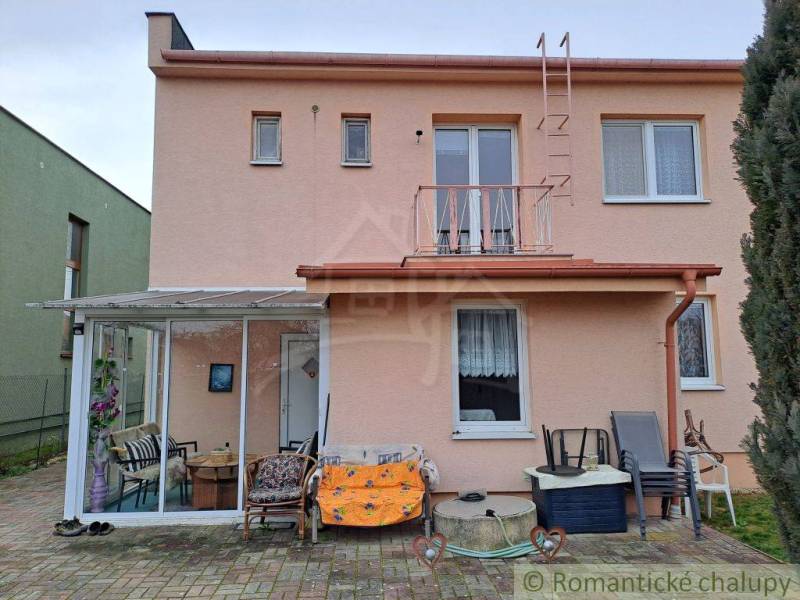 A family house in Veľké Ripňany with a glassed-in terrace and a paved courtyard.