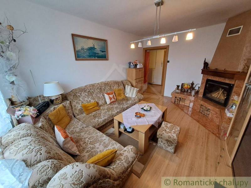 Living room in a family house with an embroidered sofa, alcove kitchen, cozy interior.