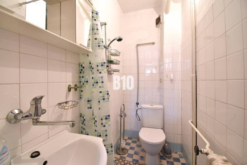 A bathroom in a family house with tiles and a shower corner.