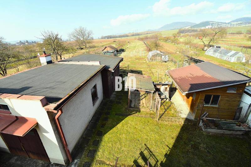 A family house in Žilina with annexes, a garden, and a view of the surrounding countryside.