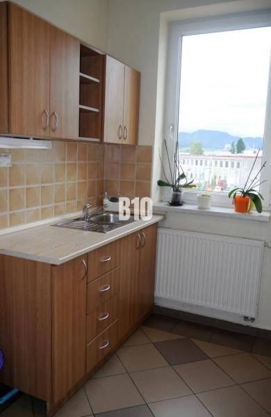 A kitchen with a wooden cabinet and a view from the window, approved by real estate agencies.