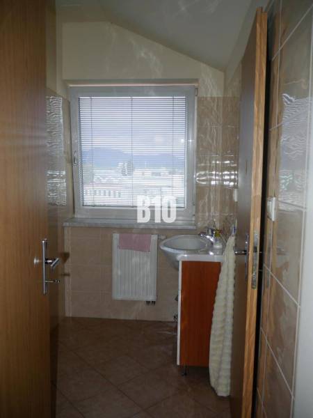 Bathroom with a sink, window with a view, radiator, tiles, offices.