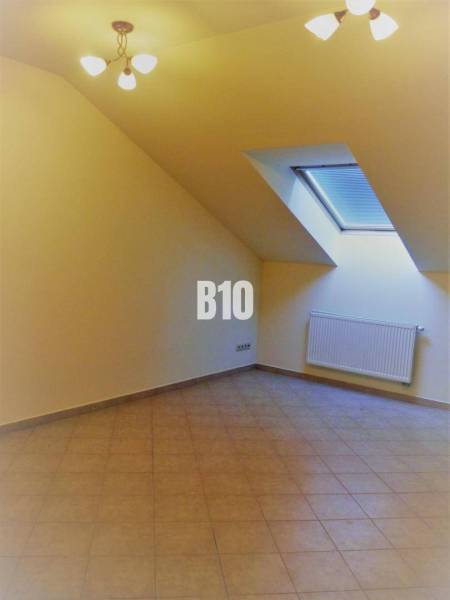An attic room with a skylight and tiles, suitable for offices.