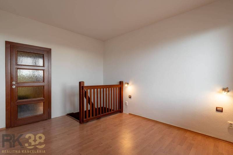 Interior of a 5 or more room apartment with wood-patterned flooring and a staircase.