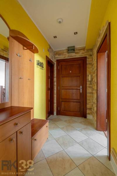 Entrance hall in a 5 or more bedroom apartment with yellow walls and wooden doors.