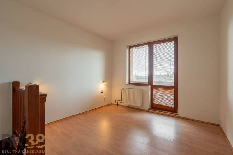 A room with a wooden decor floor in a 5 or more room apartment, light walls, large window.