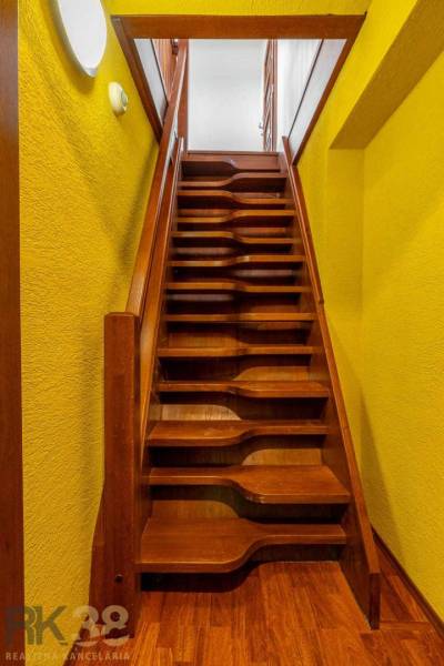 Wooden stairs and yellow walls in a 5 or more room apartment.