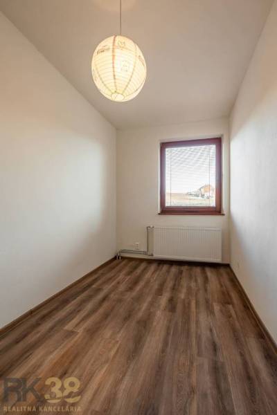 A room in a 5 or more room apartment with a wooden decor floor and a window.