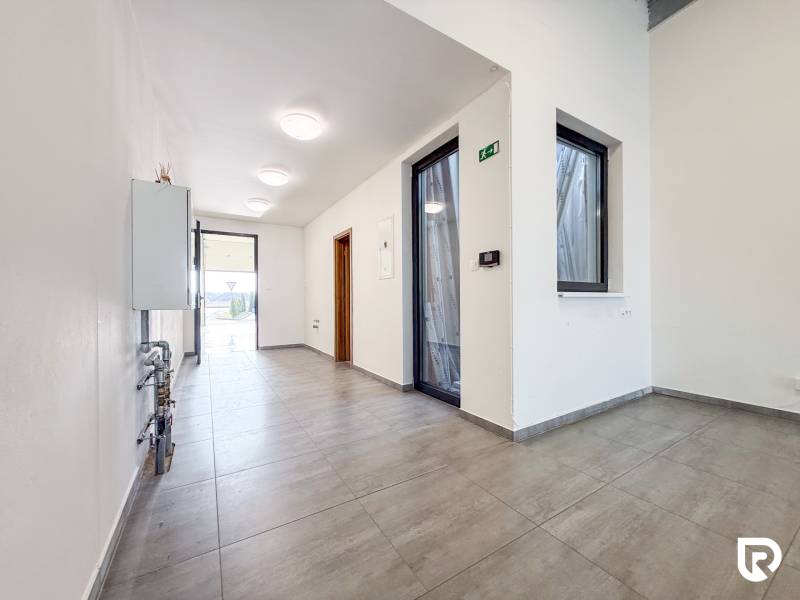 Interior of a commercial space with a tiled floor and glass doors.