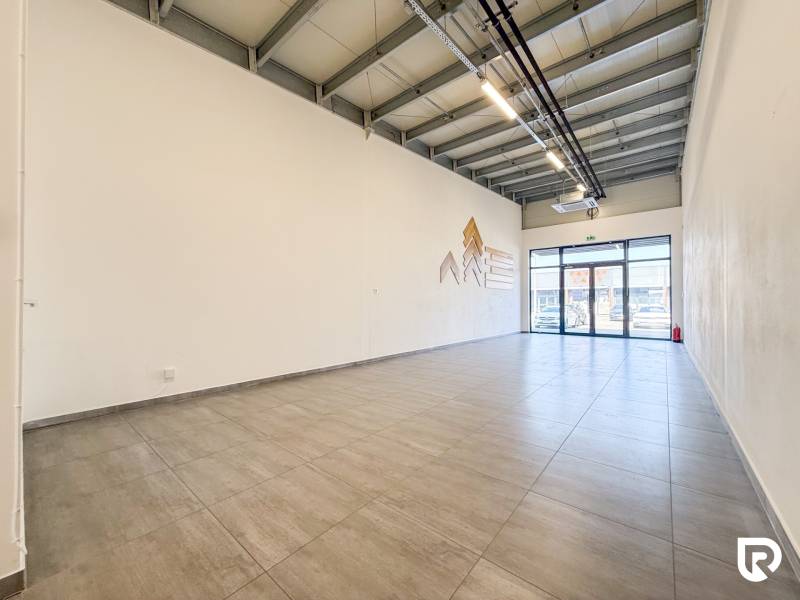 Interior of commercial spaces with large-format windows and light flooring.