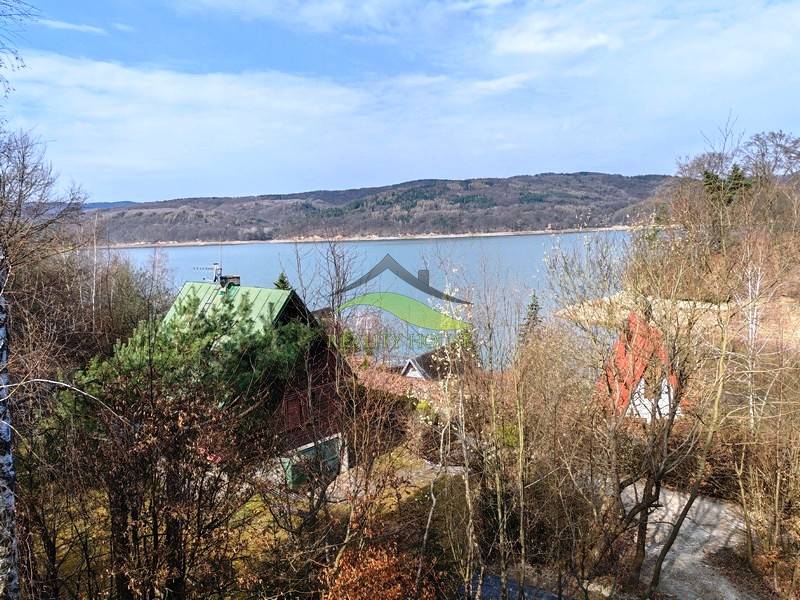 View from the cottage in Holčíkovce at Zajačia debra with a lake and forests in the background.