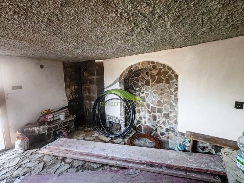 Stone interior with wood-patterned flooring in a cabin.