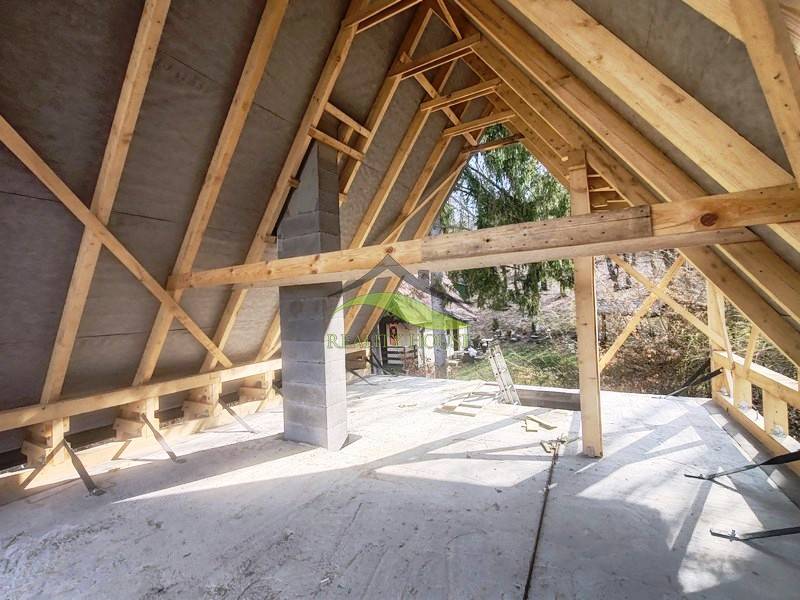 Interior of a cabin with a roof structure and a view of the outside nature.