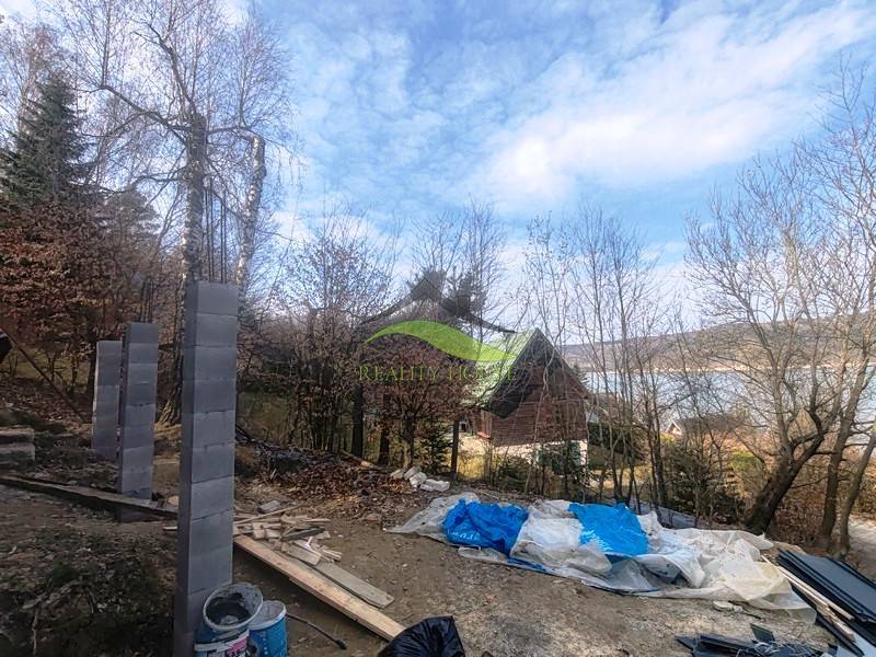 Building material next to the cottage at Zajačia debra in Holčíkovce with a view of the water surface.