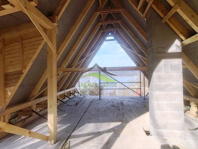 The interior of an unfinished cabin with a view of nature, floor with wooden decor.