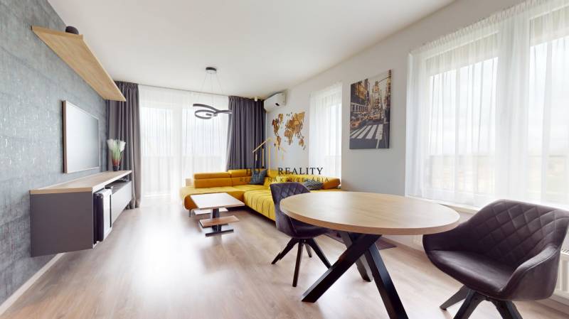 Living room in a 3-room apartment with a sofa, light curtains, and a wooden decor floor.