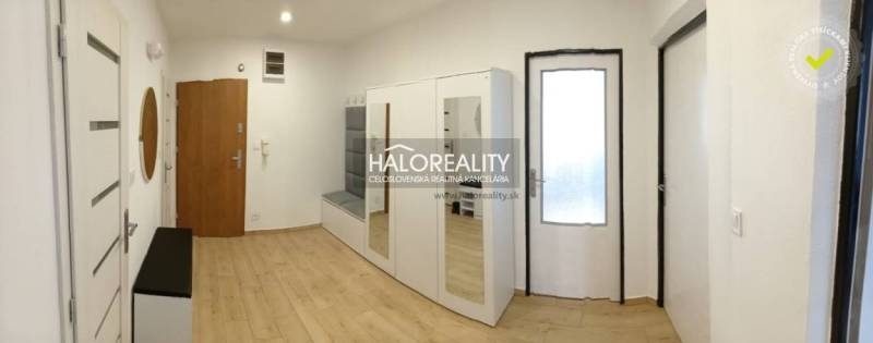 Entrance hall with a mirrored wardrobe and a floor with a wooden decor in a 3-room apartment.
