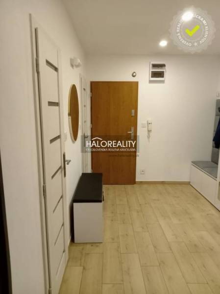 A hallway in a 3-room apartment with a wooden decor floor and white doors.