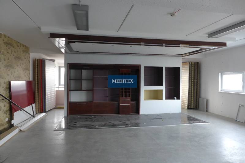 Retail space with shelves and white walls, floor with wood decor.