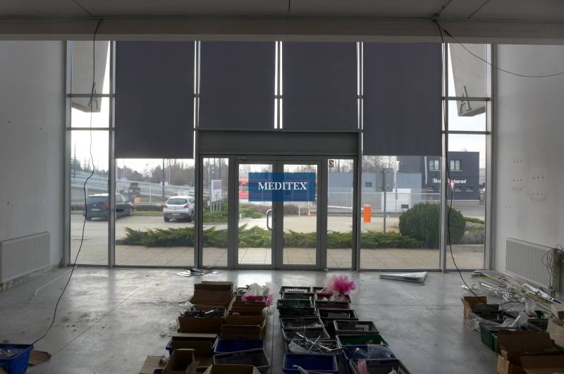 Interior of commercial premises in Bratislava with large glass doors and storage boxes.