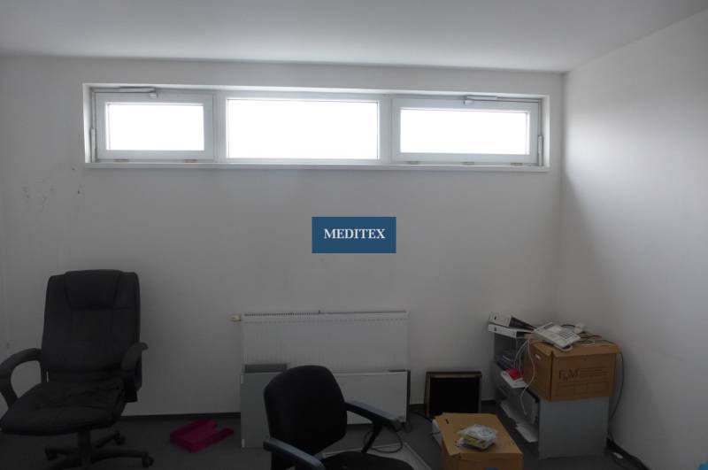 A room with a window and office chairs in commercial premises.