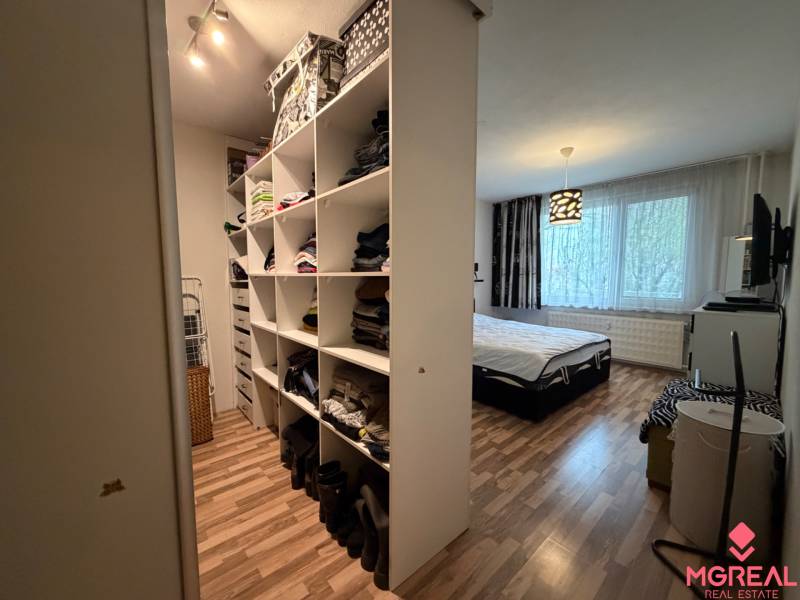 Bedroom in a 3-room apartment with storage space and flooring with a wood decor.
