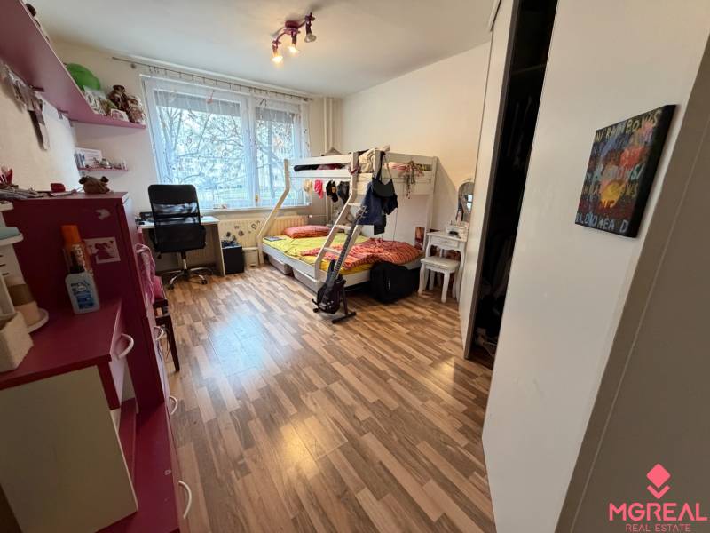 Children's room with wood-patterned flooring, a bunk bed, and a desk.