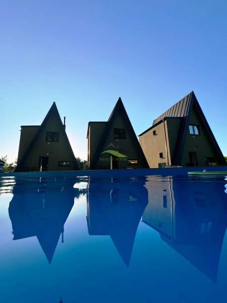 Cottages on Eva Street in Holčíkovce by the pool with a blue water surface.