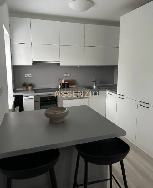 A kitchen in a 2-room apartment with simple equipment and a floor with a wooden decor.