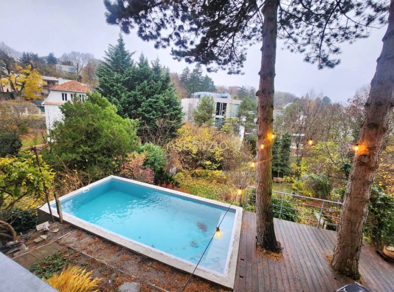View of the surrounding houses and trees with a pool in the garden on Dolná Street.