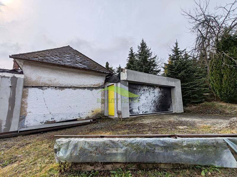 A family house on Hlavná Street in Piskorovce surrounded by trees and grass.