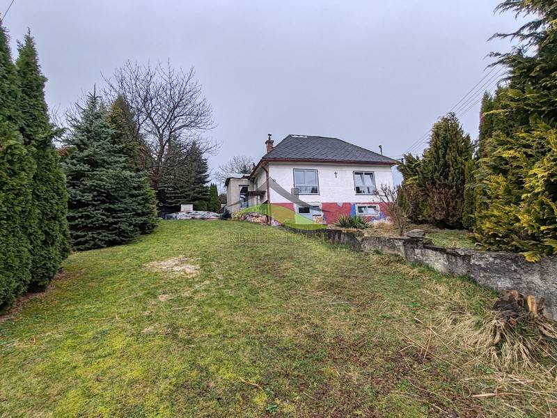 A family house on Hlavná in Piskorovce surrounded by trees and a grassy yard.