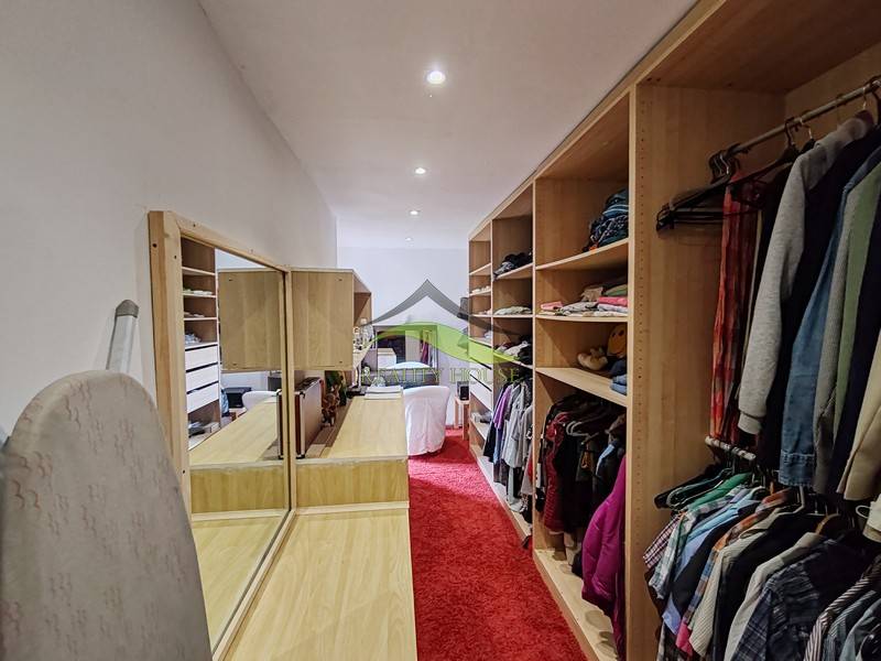 A wardrobe in a family house with a red carpet and built-in shelves.